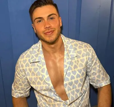 Actor Alex Dourassof looks good in white printed shirt with shirt buttons open