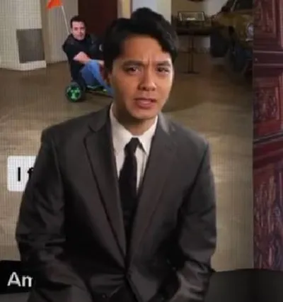 Actor Jordan Mendoza wearing a black suit and tie