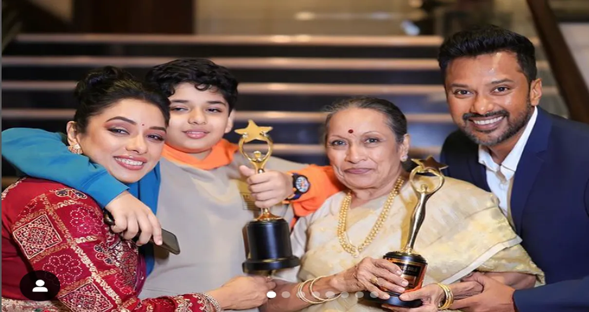 Rupali Ganguly An Indian televijan family proudly poses with their awards, smiling and standing together in traditional attire.