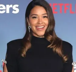 Actress Gina Rodriguez at premiere of Netflix's 'Players', wearing an elegant gown and smiling for the cameras.